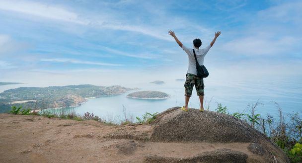 Samotny szczęśliwy człowiek fotograf lub podróżnik stojąc i myśląc coś i zobaczyć piękne krajobrazy krajobraz natura widok na skale góry w phuket Tajlandii - Zdjęcie, obraz