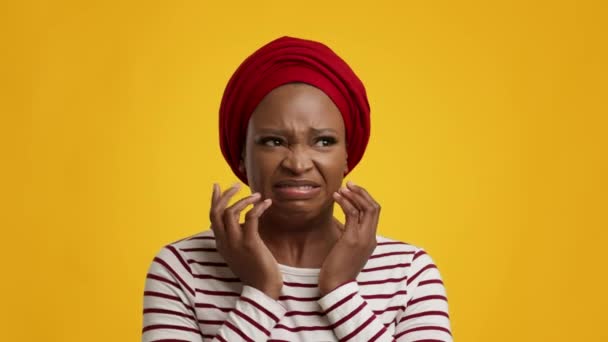 Nervózní černošky žena znepokojující pocit strachu přes žluté studio pozadí - Záběry, video