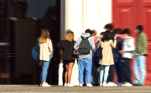 Gruppe junger Leute auf dem Bürgersteig am Eingang eines Museums - Foto, Bild