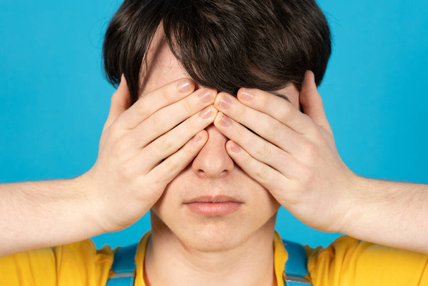 Portrait of teenager covering his eyes with hands. - Photo, Image