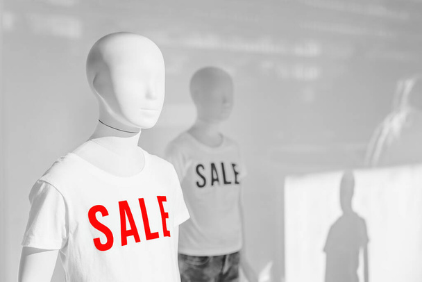 Mannequin with Sale t-shirts in fashion clothes store shop window, selective focus - Foto, immagini