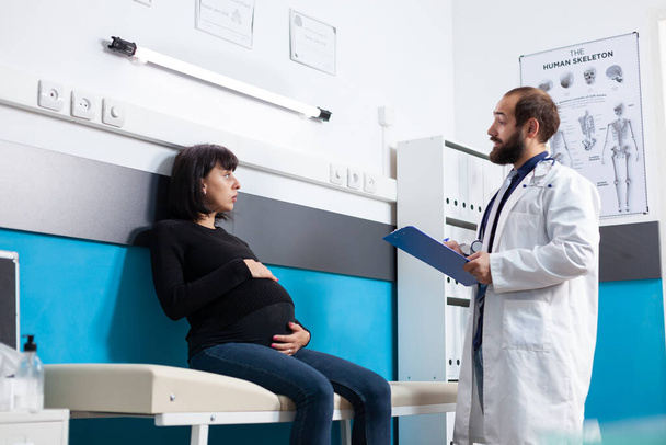 A szülészeten várandós beteget vizsgáló orvos - Fotó, kép