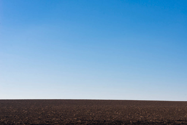 Ploughed field and blue sky as a background.  - Фото, зображення