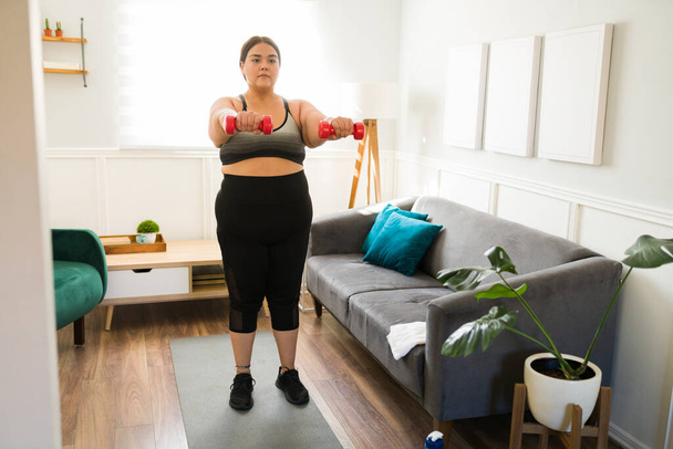 Beautiful obese young woman exercising and losing weight. Plus size woman dieting and working out at home - Zdjęcie, obraz