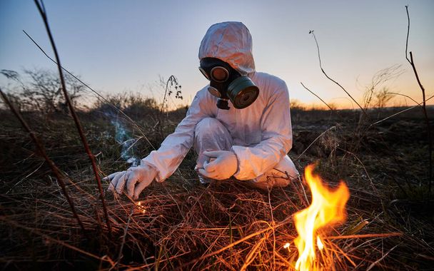 Persona irriconoscibile che brucia vecchia erba secca in campo - Foto, immagini