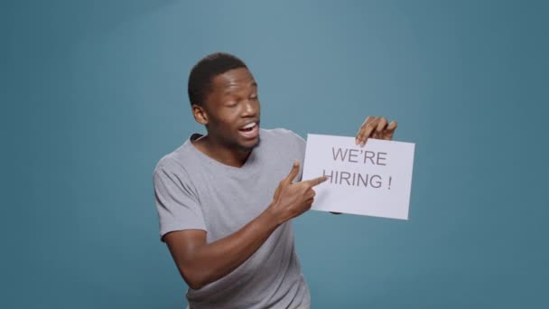 Empleado de la empresa mostrando el signo de solicitud de contratación en papel - Metraje, vídeo