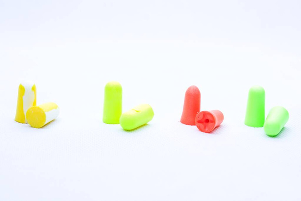 Pairs of earplugs against noise in different colors isolated on white background.Protective equipment - earplugs against noise. Hearing protection. Necessity in a noisy environment. - Foto, afbeelding