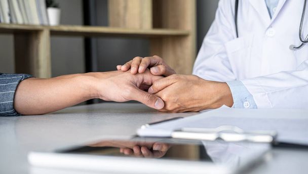 Close up of doctor touching patient hand for encouragement and empathy on the hospital, cheering and support patient, Bad news, medical examination, trust and ethics. - Foto, Bild