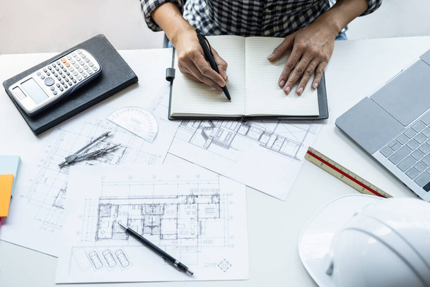Architect working on blueprint, Engineer working with engineering tools for architectural project on workplace, Construction concept - building project, blueprints, ruler and dividers. - Foto, imagen