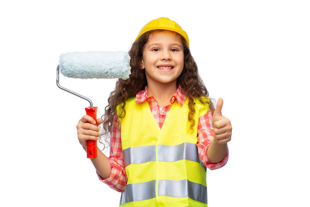 girl in helmet with paint roller showing thumbs up - Фото, зображення
