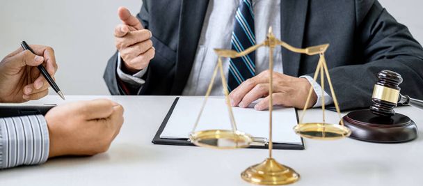 Judge gavel with scales of justice, Businessman and lawyer or counselor consulting and discussing contract papers at law firm in office. - 写真・画像