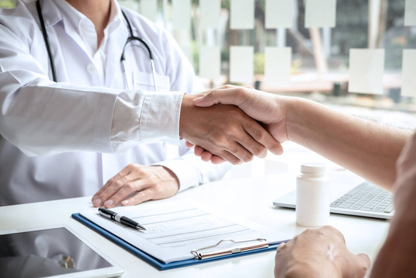Professional Male doctor in white coat handshake with the patient after successful in recommending treatment method. - Foto, Imagen
