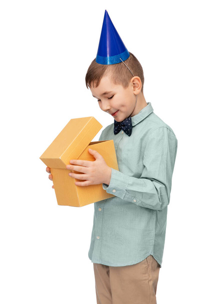 smiling boy in party hat with birthday gift - Fotoğraf, Görsel