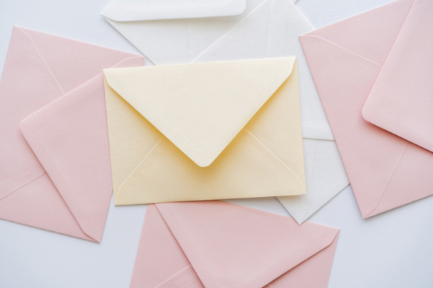 top view of pastel envelopes on white - Фото, зображення