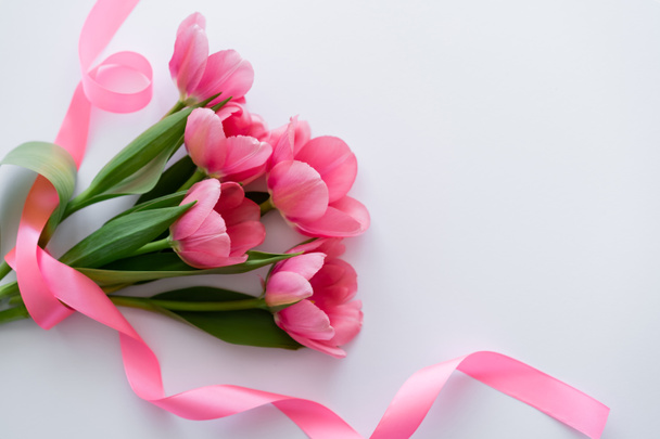 top view of ribbon near bouquet of pink tulips on white - Φωτογραφία, εικόνα