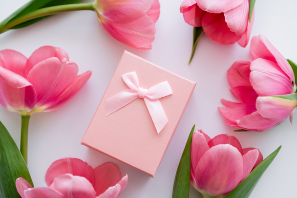 vista da vicino della confezione regalo vicino a fiori rosa brillante su bianco  - Foto, immagini