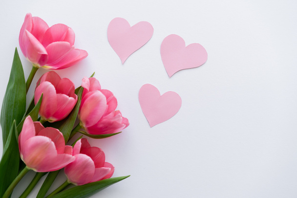 vista superior de buquê de tulipas perto de corações de papel em branco - Foto, Imagem