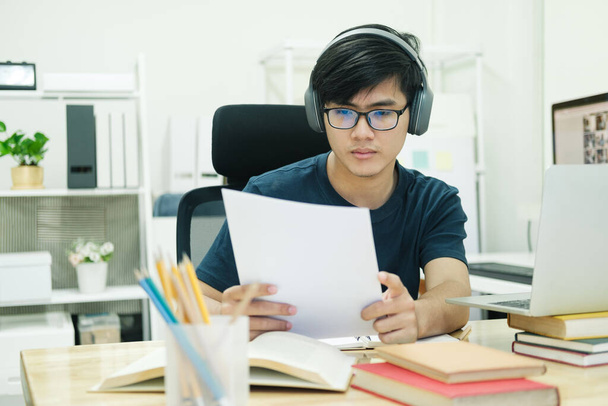 Hombre joven estudio en frente de la computadora portátil en casa - Foto, imagen