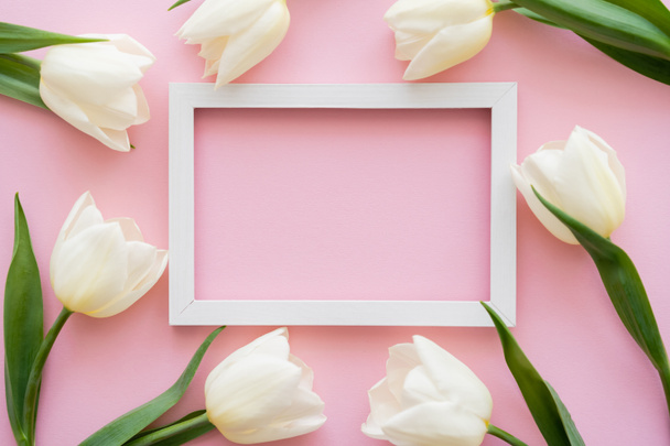 top view of white frame near tulips on pink  - Zdjęcie, obraz