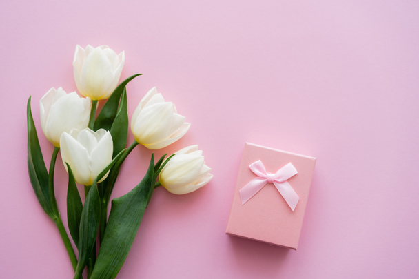 top view of white tulips near gift box on pink - Fotó, kép