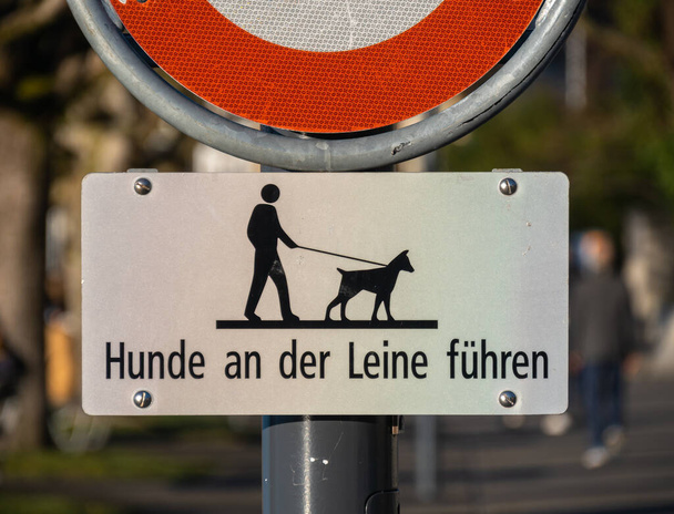 Zug, Schweiz - 31. Dezember 2021: Warnschild vor dem Weg für Spaziergänger am Zuger See mit der Aufschrift "Hund an der Leine halten" - Foto, Bild