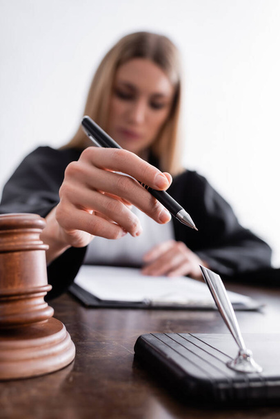 selective focus of pen in hand of prosecutor reading verdict on blurred background - Foto, Imagem
