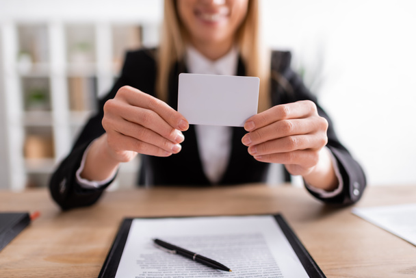 partial view of blurred notary holding blank business card  - Foto, Imagem