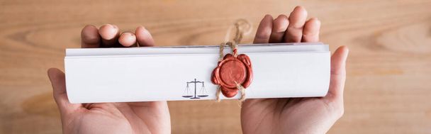 Kırpılmış noter ve pankartın ellerinde balmumu mühür ile damgalanmış sözleşmenin üst görünümü - Fotoğraf, Görsel