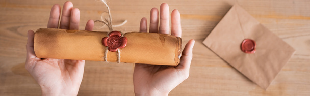 partial view of notary holding rolled craft paper with wax seal and rope, banner - Photo, Image