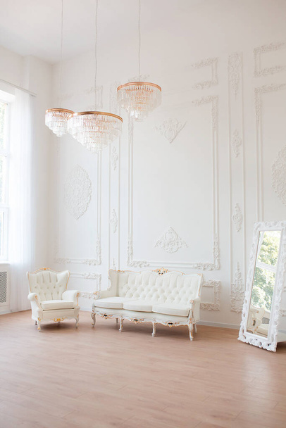 Riche intérieur de luxe d'une chambre de style classique avec mobilier vintage, grandes fenêtres, miroir, lustres et canapé élégant. - Photo, image