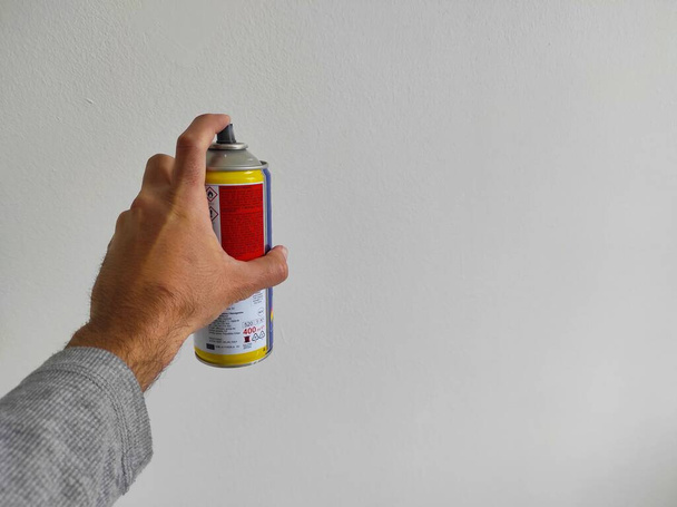 hombre pintura pared blanca con spray - Foto, imagen