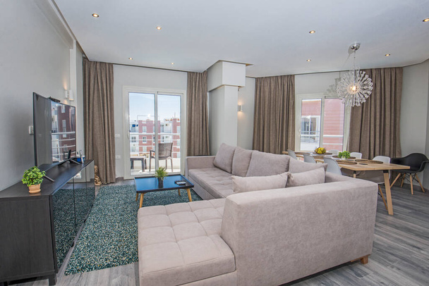 Пространство гостиной в роскошных апартаментах с дизайнерским интерьером и балконом - Фото, изображение
