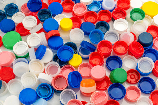 цветные бутылочные пластиковые крышки для вторичной переработки материала в виде сверху - Фото, изображение