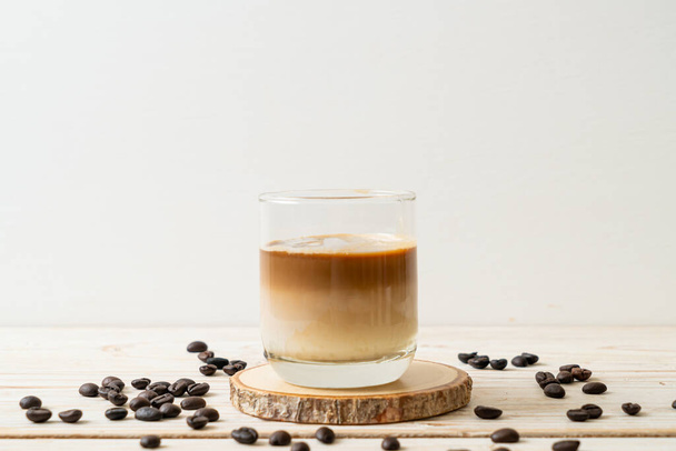 Dirty coffee glass, cold milk topped with hot espresso coffee shot - Фото, изображение