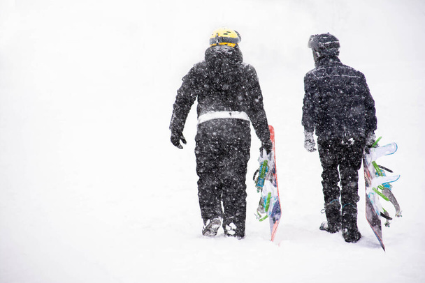 Snowboarders e esquiadores escalam as montanhas para uma descida - Foto, Imagem