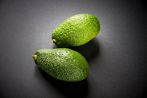 Two fresh avocados isolated on a black background - Foto, Imagem