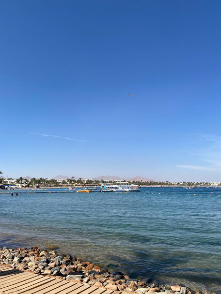 Gyönyörű tengerpart a Vörös-tengeren, Egyiptomban. Város és strand, Naama 'ama Bay. Egyiptomi hotel üdülőhely és spa kilátás kék ég - Fotó, kép
