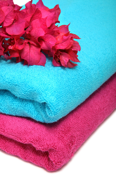 Розовые и голубые полотенца с цветами на столе
 - Фото, изображение
