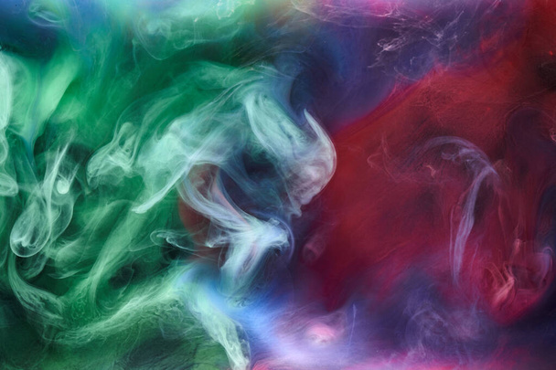 Green pink smoke on black ink background, colorful fog, abstract swirling touch ocean sea, acrylic paint pigment underwater - Foto, immagini