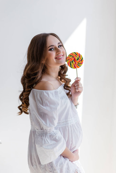 beautiful pregnant woman eating tasty sweet cakes at home - Fotografie, Obrázek