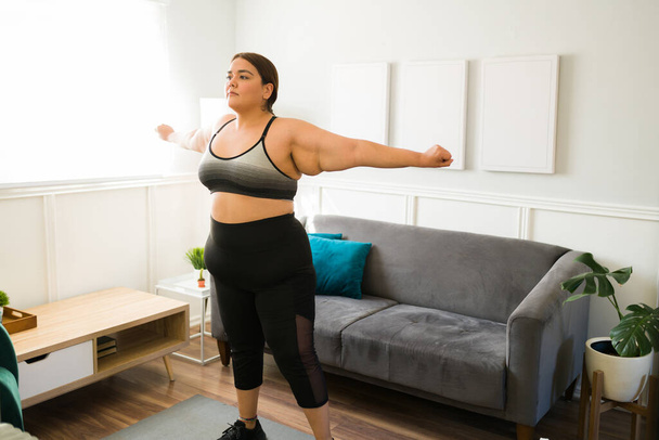 Мотивированная толстая молодая женщина делает кардио-упражнения. Плюс размер женщины, тренирующейся и пробующей новые тренировки - Фото, изображение