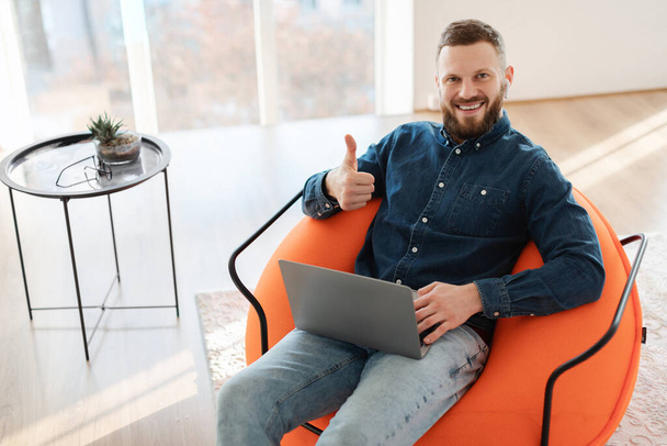 Cheerful Entrepreneur Guy Using Laptop Gesturing Thumbs Up At Home - Photo, Image
