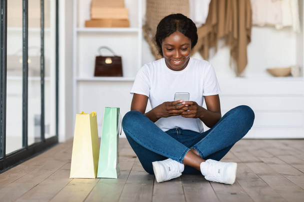 Happy Black Femme Acheteur Shopping en ligne en utilisant un téléphone portable à la maison - Photo, image