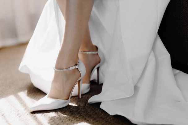 Scarpe bianche da sposa sui piedi della sposa. Primo piano. Foto di alta qualità - Foto, immagini
