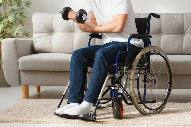Man Disabled. Sports for Disabled. Male in Wheelchair with Dumbbells in Hands. Man with Dumbbells in Hands. Father Disabled Do Spotting. Sport at Apartment. Health Concept. Healthy Lifestyle. - Фото, изображение