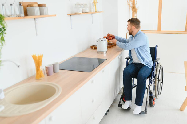 вдумливий молодий інвалід на інвалідному візку вдома
 - Фото, зображення