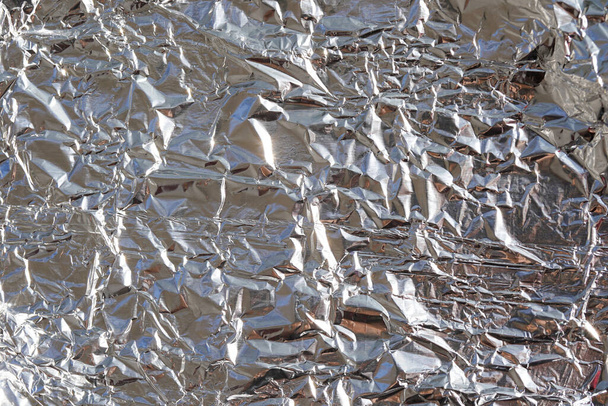 Stříbrná fólie pozadí s lesklým zmačkaným povrchem pro texturu pozadí - Fotografie, Obrázek