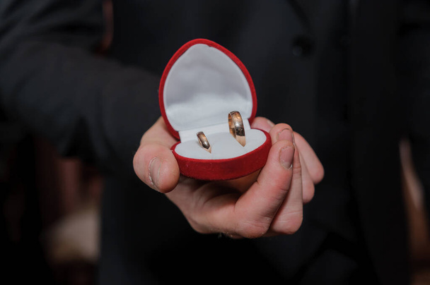 Caixa vermelha com anéis de casamento nas mãos de um homem - Foto, Imagem
