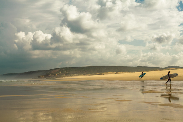 Couple surfers walks along the beach in gold coast - Foto, afbeelding