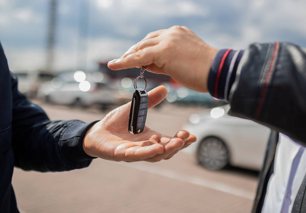 lose up. Hand giving a car key . Concept of successful car transaction sale-purchase deal - Foto, Imagen